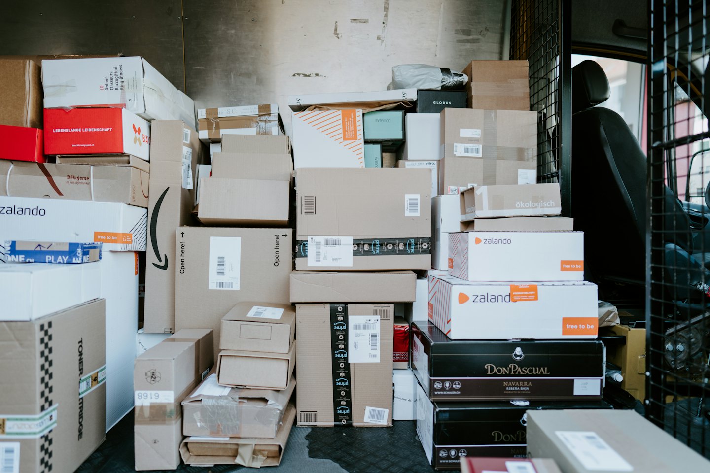 Interior of a delivery van packed with cardboard boxes and packages.